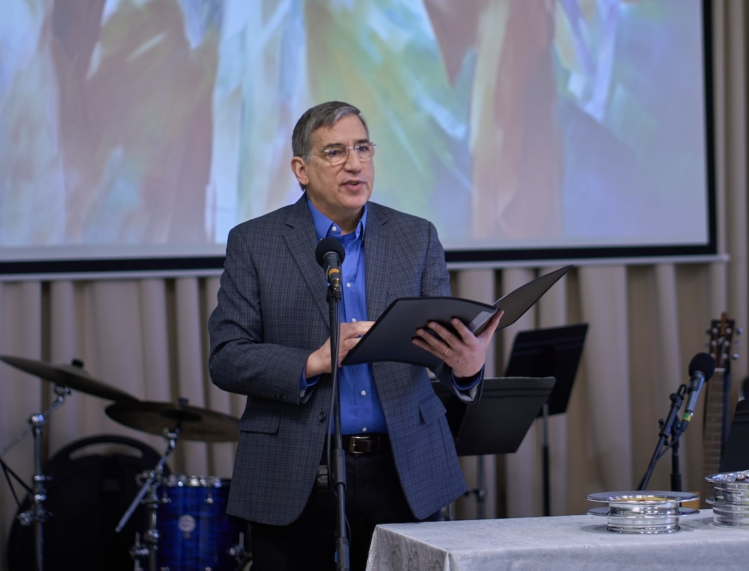 Minister Paul Condrell speaking into a microphone at WCEC in Hockessin, DE